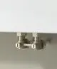 Kermi Heizkörper mit zwei Ventilen und Anschlussrohren, montiert an einer Wand. Die Ventile sind aus Metall und haben eine einfache Handhabung.