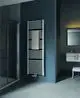 Kermi-Badheizkörper in glänzendem Silber, vertikal montiert, mit starren Längsrippen. Handtuch liegt auf dem Heizkörper. Modernes Badezimmerdesign mit eleganter Wandgestaltung.