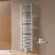 Kermi-Heizkörper, vertikal montiert, mit gebogenen Rohren vor einer hellen Wand im Badezimmer, neben einem Duschbereich und einem kleinen Tisch mit Pflegeprodukten.