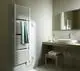 Ein weißer Kermi Bad- und Wohnheizkörper Duett-E hängt an einer Wand in einem Badezimmer. Ein grünes Handtuch hängt über dem Heizkörper.