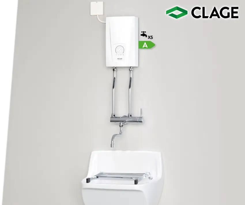 Weißer E-Durchlauferhitzer von CLAGE, installiert an einer Wand, mit zwei entwässernden Rohrleitungen und einem Wasserhahn über einem Waschbecken.