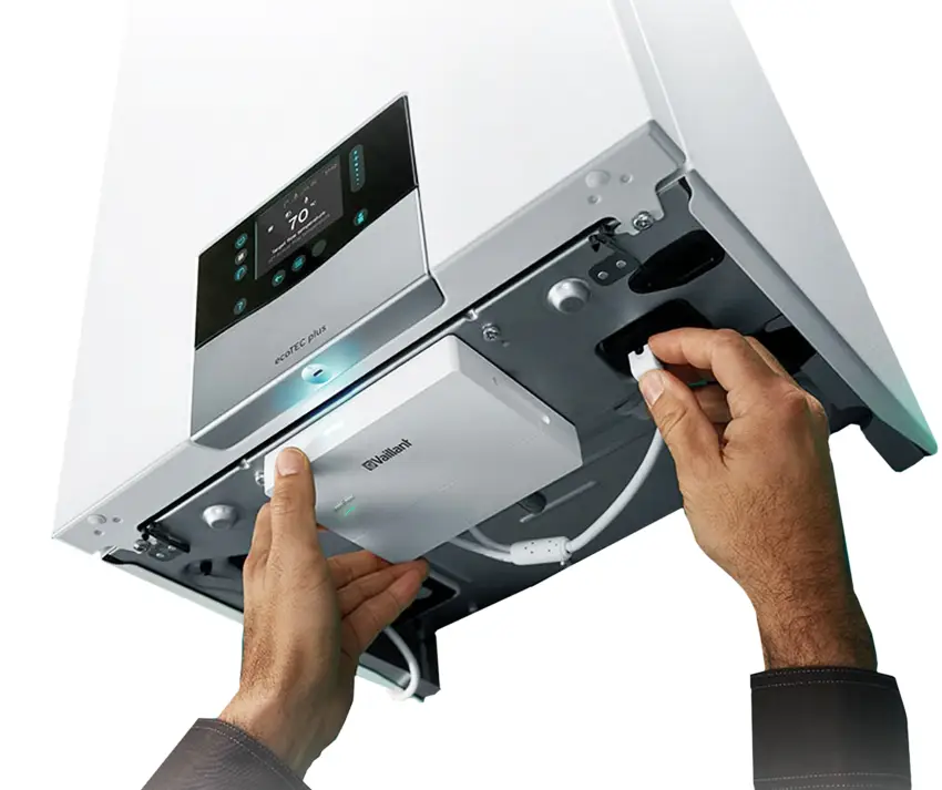 Vaillant Heizgerät mit Bedienfeld und abnehmbarem Zubehör in der unteren Einheit. Ein Benutzer hält ein Kabel in der Hand und interagiert mit dem Gerät.