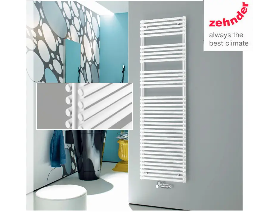 Vertikaler Heizkörper in Weiß vor einer hellen Wand, abgebildet in einem modernen Raum mit einem Spiegel und dekorativen Elementen. Marke: Zehnder.