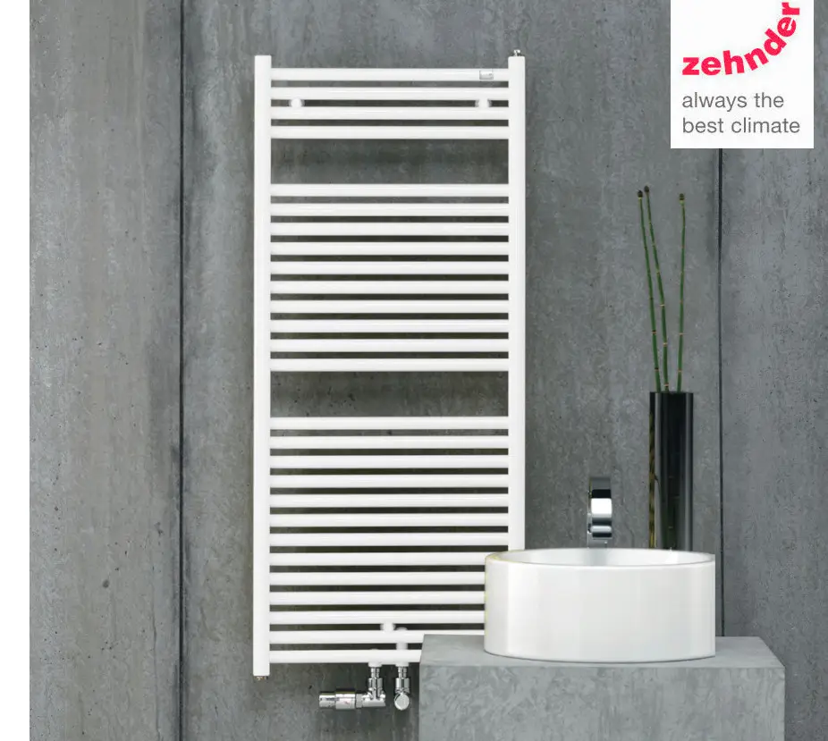 Zehnder Heizkörper mit horizontalen Längsrippen, in Weiß, montiert an einer grauen Wand, neben einem ovalen Waschbecken und einer schwarzen Vase mit Pflanzen.