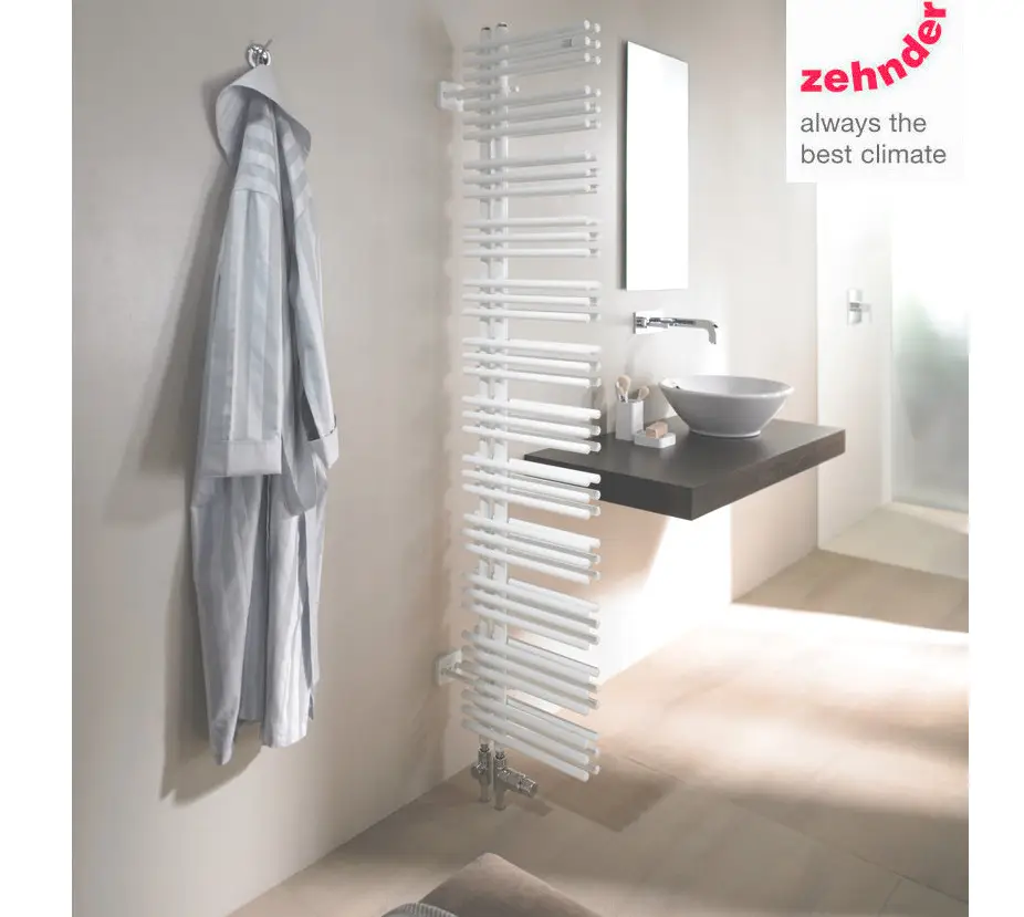 Weißer, vertikal montierter Heizkörper von Zehnder mit horizontalen Röhren, neben einem Spiegel und einer modernen Waschschüssel in einem hellen Badezimmer.