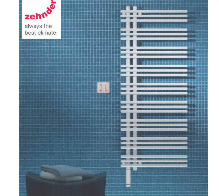Zehnder Elektroheizkörper in weißer Farbe, montiert an einer blauen Fliesenwand. Neben dem Heizkörper befindet sich ein Bedienfeld. Eine gefaltete Lenkertasche liegt auf einem Hocker.