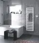 Zehnder Elektroheizkörper in vertikaler Form, weiß, mit gerillter Oberfläche, an der Wand im Badezimmer installiert, neben einer Badewanne und einer schwarzen Sitzfläche.