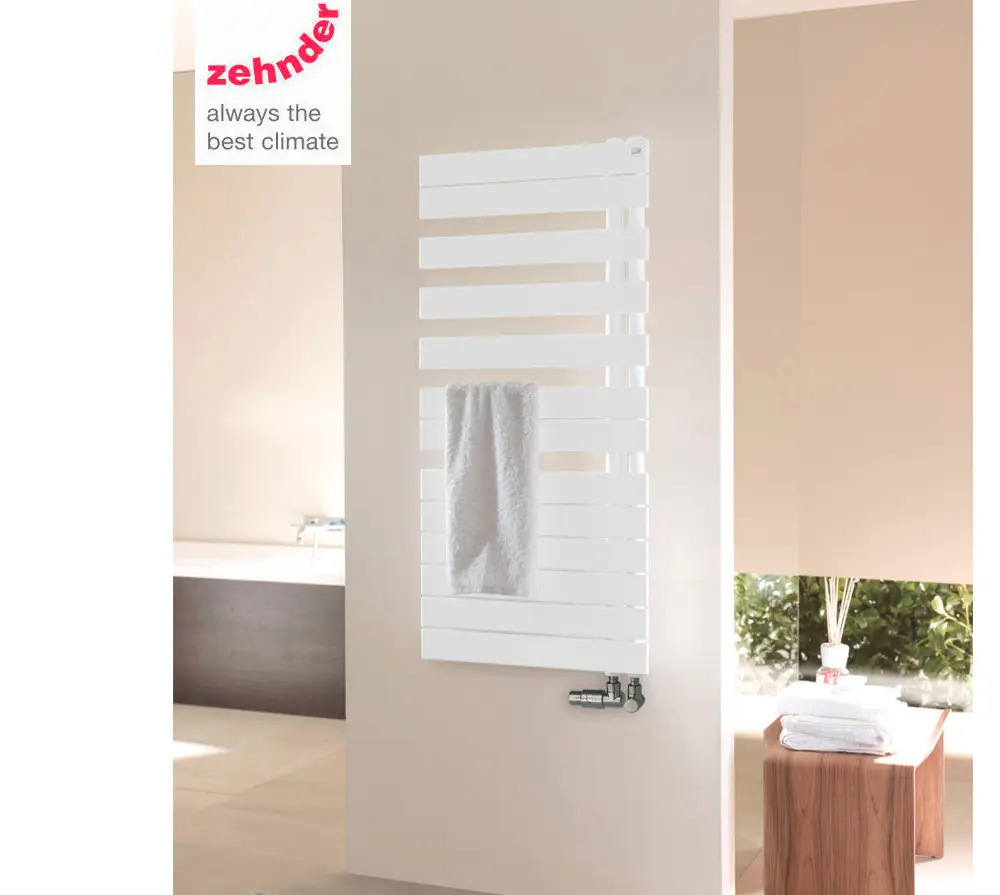 Vertikaler weißer Heizkörper von Zehnder mit lamellenförmigen Elementen, an einer Wand montiert. Ein Handtuch hängt daran. Heller, moderner Raum.