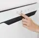 Hand, die einen Knopf an einem Elektroheizkörper von Zehnder drückt. Der Heizkörper hat ein einfaches Design mit Steuerungselementen oben und ist an der Wand montiert.
