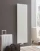Purmo-Heizkörper, vertikal und flach, weiß vor grauer Wand, kombiniert mit einem silbernen Koffer und einer dunklen Tasche im modernen Wohnraum.
