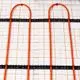 Purmo Klemmschiene aus orangefarbenem Material, mit mehreren Bögen und schwarzen Halterungen, auf einem weißen Untergrund mit orangefarbener Gitterstruktur.