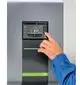 Bedienfeld eines Kermi-Geräts mit Touchscreen-Anzeige. Der Nutzer zeigt auf die Funktionen zur Temperatur- und Heizungssteuerung. Das Display zeigt 8,4 °C an.