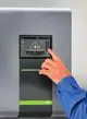 Wandregler mit Touchscreen von Kermi zur Regelung einer Wärmepumpe. Anzeige von Temperatur und Betriebsstatus, Handsteuerung in Aktion.
