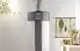 Kermi-Wärmepumpe in vertikaler Ausrichtung, mit einem funktionalen Display, vor einer hellen Wand und umgeben von Pflanzen und Wanddekoration.
