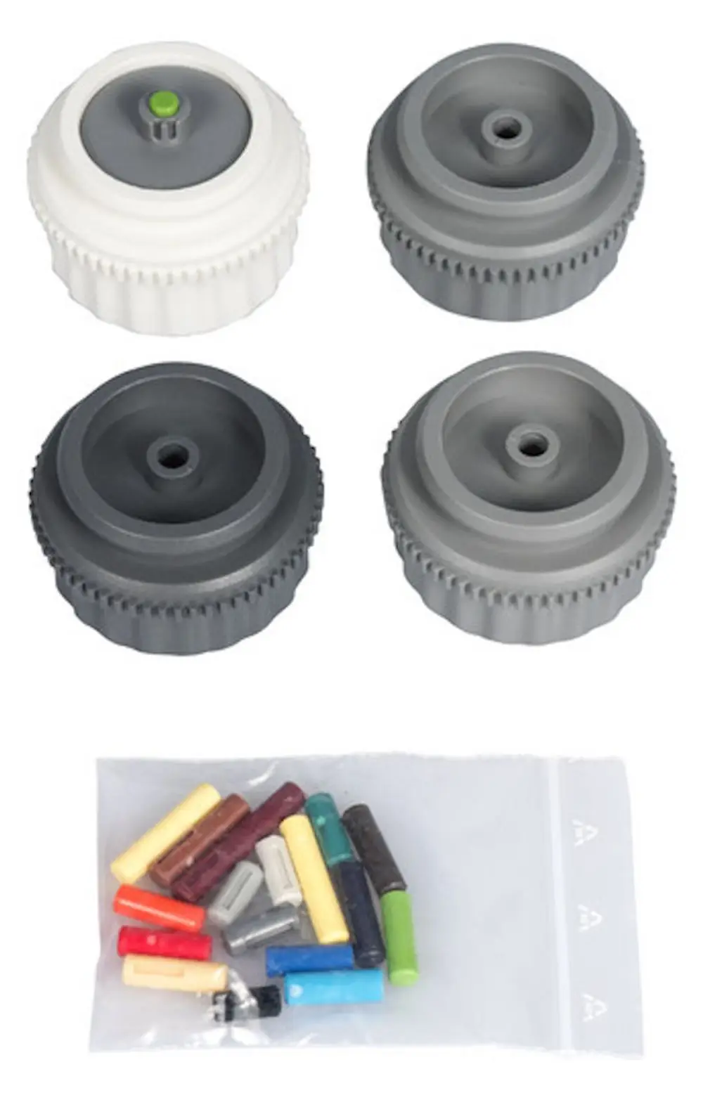 Vier Ventiladapter in unterschiedlichen Grautönen und ein weißer Adapter mit grünem Indikator, begleitet von farbigen Zubehörteilen, präsentiert auf einer durchsichtigen Verpackung.