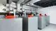 Viessmann Wärmepumpen in einem technischen Raum, mit mehreren silbernen Gehäusen und digitalen Steuerungen auf jedem Gerät. Rohrleitungen verlaufen über dem Boden.