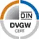 Logo der DVGW-Zertifizierung, umrandet mit grauem und orangefarbenem Halbkreis, mit dem Schriftzug „DIN DVGW CERT“ in der Mitte, auf weißem Hintergrund. Flamco-Produkt für Trinkwasseranwendungen.