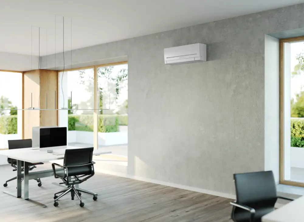 Stiebel Eltron Klimagerät an der Wand eines modernen Büros, mit zwei Bürostühlen und einem Schreibtisch in einem Raum mit großen Fenstern und Holzelementen.