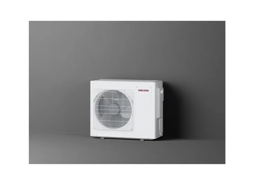 Weißes Außengerät von Stiebel Eltron mit einem großen Ventilator und Gitter an der Front, montiert an einer grauen Wand.