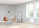 Weißer Wandheizkörper von Stiebel Eltron in einem modernen Raum, montiert unter einem Fenster, umgeben von Holzfußboden und einem Tisch mit Stühlen.