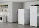 Weißer Wasserspeicher von Stiebel Eltron in einem modernen Raum. Neben einem Waschmaschinenraum ist eine Ablage mit Handtüchern zu sehen, sowie Fenster mit natürlichem Licht.