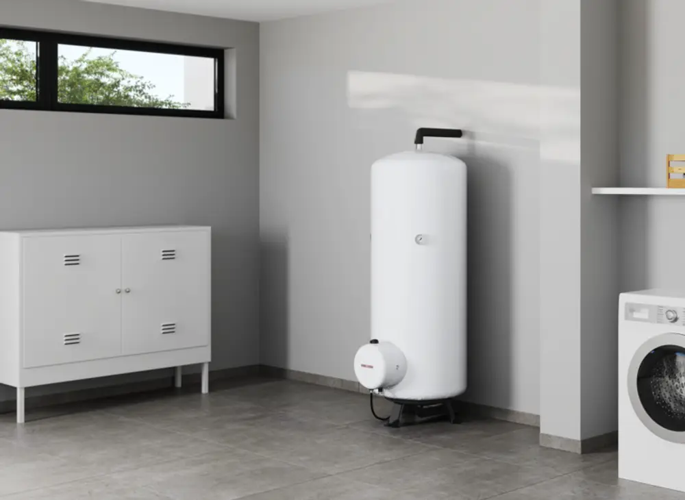 Weißer Standspeicher für Warmwasser von Stiebel Eltron in einem modernen Raum, ausgestattet mit einem Zubehörteil. In der Nähe steht eine Waschmaschine und ein Schrank.