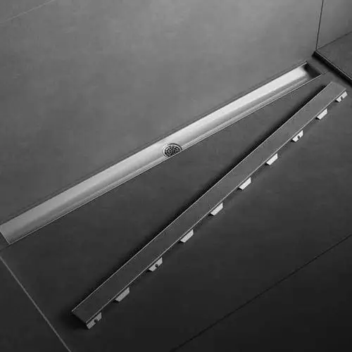 Ein modernes Duschablauf-System in einem minimalistisch gestalteten Badezimmer, bestehend aus grauen Fliesen und einem schmalen Wandablauf.
