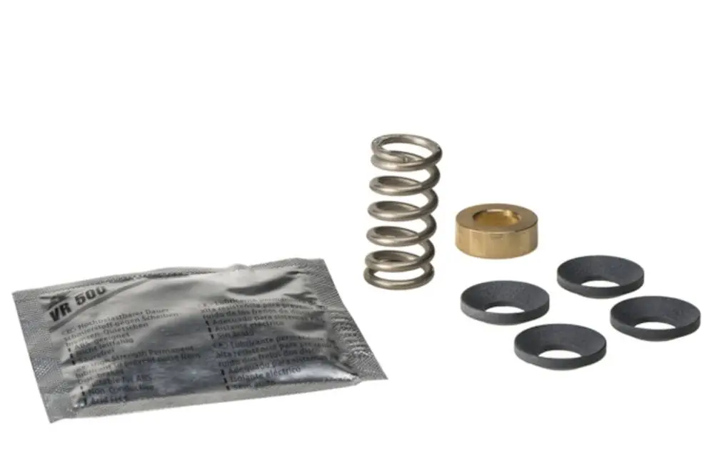 Bauteile eines Packungsringsatzes, bestehend aus einer Feder, einer Metallhülse, mehreren Gummiringe und einer Verpackung mit Resideo-Label.