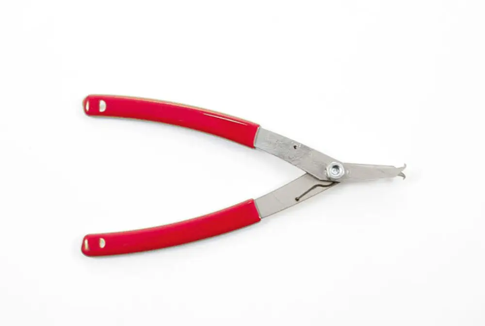 Zange mit roten Griffen und metallischen Arbeitsflächen, wahrscheinlich für das Arbeiten an Ventilen, hergestellt von Resideo.