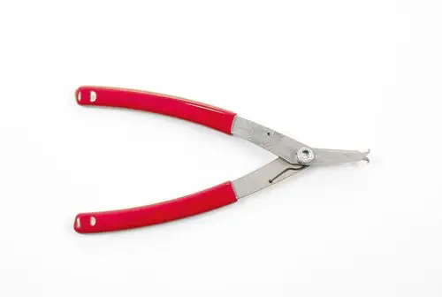 Zange mit roten Griffen und metallischen Arbeitsflächen, wahrscheinlich für das Arbeiten an Ventilen, hergestellt von Resideo.