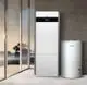 Weißer Buderus-Warmwasserspeicher und Heizgerät in modernem Raum, abgestellt neben großen Glasfenstern mit Blick auf die Landschaft.