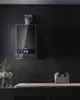 Buderus Gas-Brennwertgerät an einer dunklen Wand montiert, mit digitalem Display zur Steuerung, daneben eine gepolsterte Ablage und dekorative Elemente.