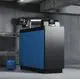 Gas-Brennwertkessel von Buderus in einem technischen Raum, mit schwarzer und blauer Verkleidung, angeschlossen an Rohre und einem Reglerschirm oben.