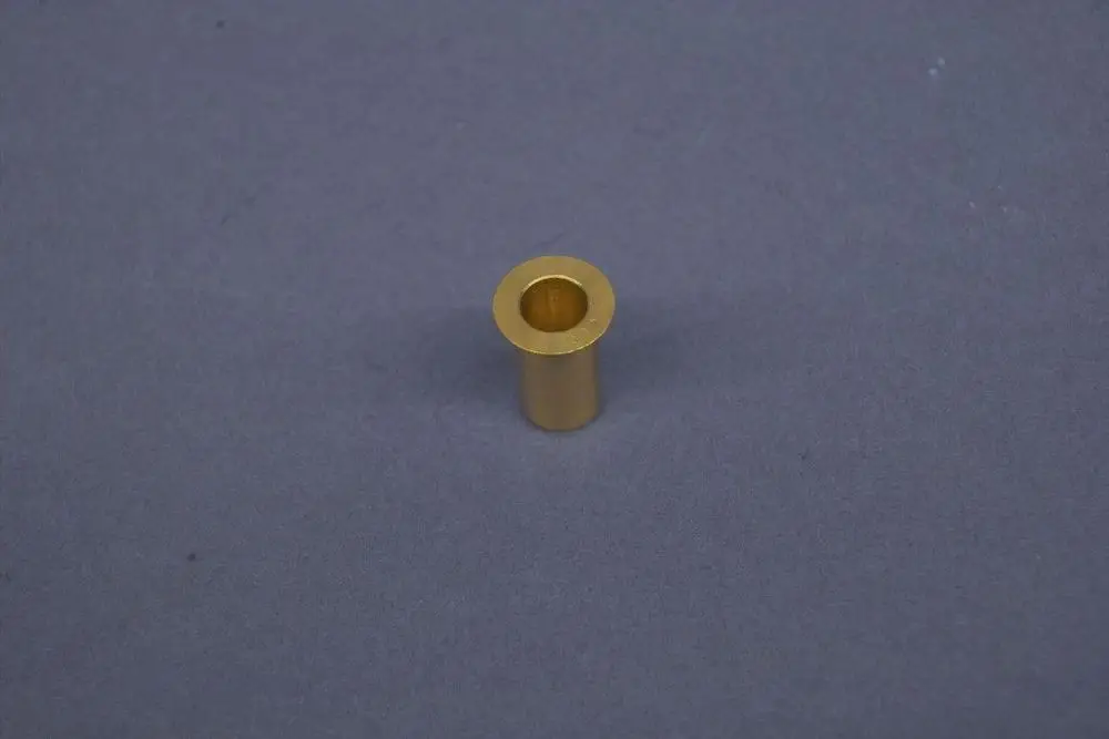 Zylindrisches Metallteil in Goldfarbe, mit einer Öffnung in der Mitte. Es könnte sich um ein Bauteil von Brötje handeln, möglicherweise für Heizungsanlagen oder industrielle Anwendungen.