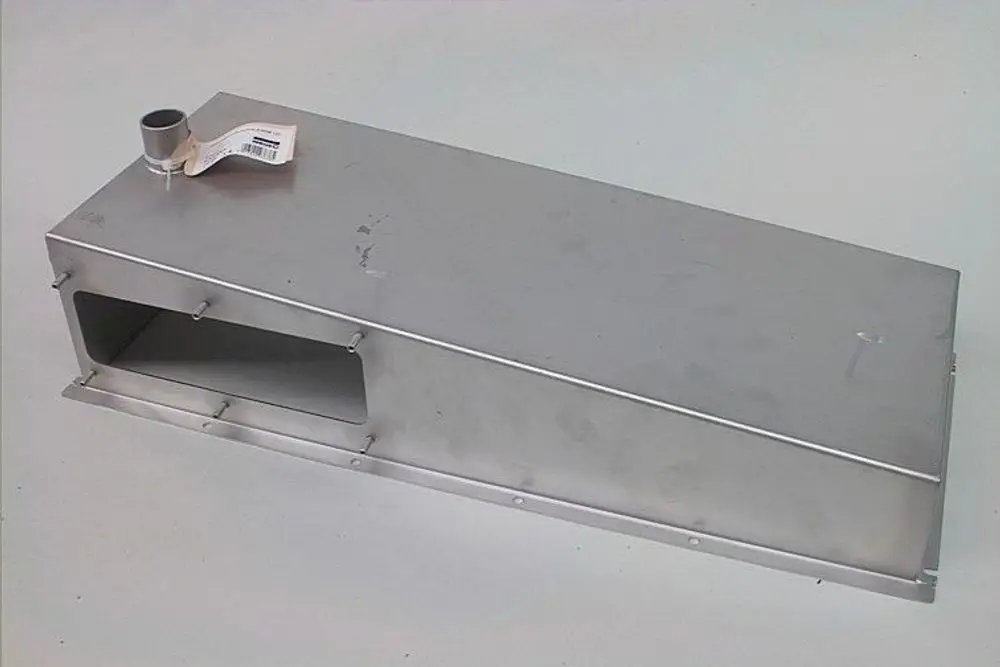 Edelstahlgehäuse von Brötje mit seitlicher Öffnung für Abgasführung. Das Produkt hat eine flache, rechteckige Form und eine Anschlussstelle oben.