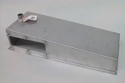 Edelstahlgehäuse von Brötje mit seitlicher Öffnung für Abgasführung. Das Produkt hat eine flache, rechteckige Form und eine Anschlussstelle oben.