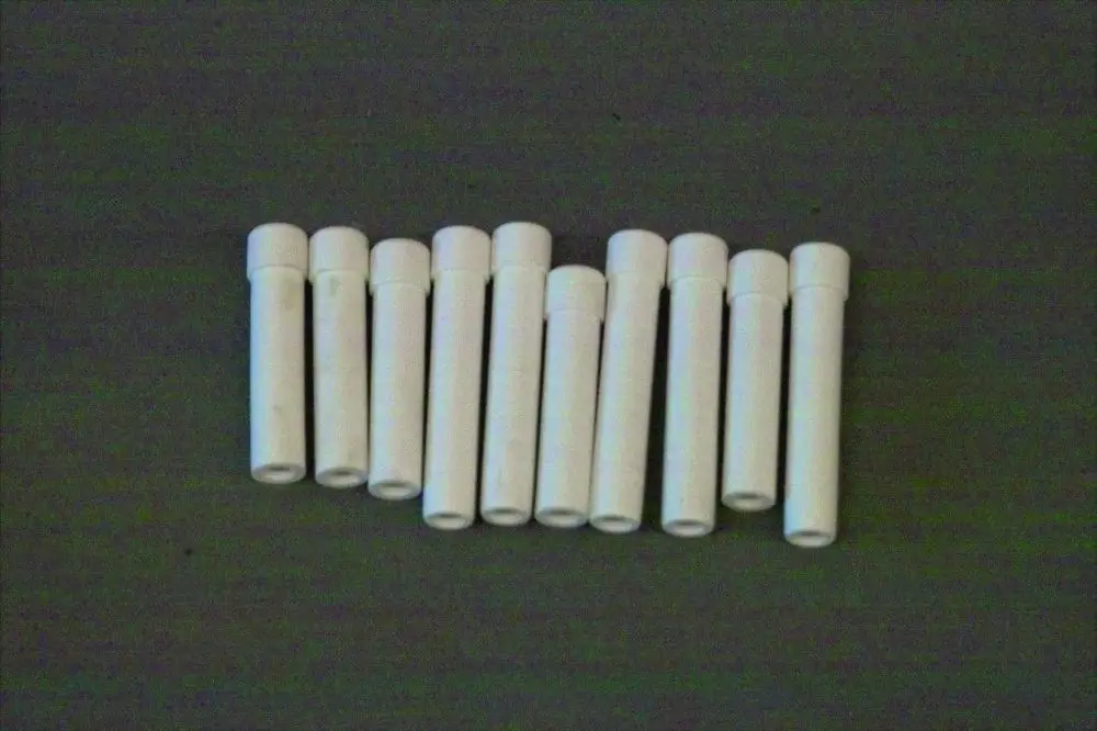 Verschiedene weiße Gasköpfe von Brötje, auf einer Unterlage angeordnet. Alle Objekte haben eine zylindrische Form mit einem verschlossenen oberen Ende.