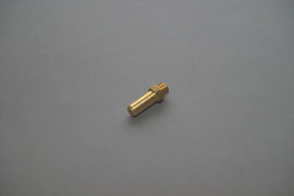 Metallische Düse von Brötje, zylindrische Form mit Gewinde und glatter Oberfläche, auf grauem Hintergrund liegend.
