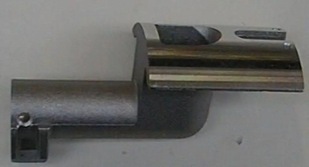 Brötje Gasschlitten, metallisches Bauteil mit einer gebogenen Form und einer Aufnahme. Es zeigt eine Verbindung für einen Heizungs- oder Gasbetrieb.