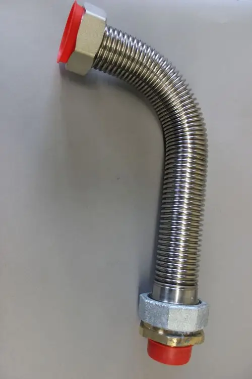 Flexibler Gasschlauch mit gewellter Oberfläche und roten Abschlusskappen. Unterlegscheibe und gewindeartige Verbindung erkennbar. Brötje.