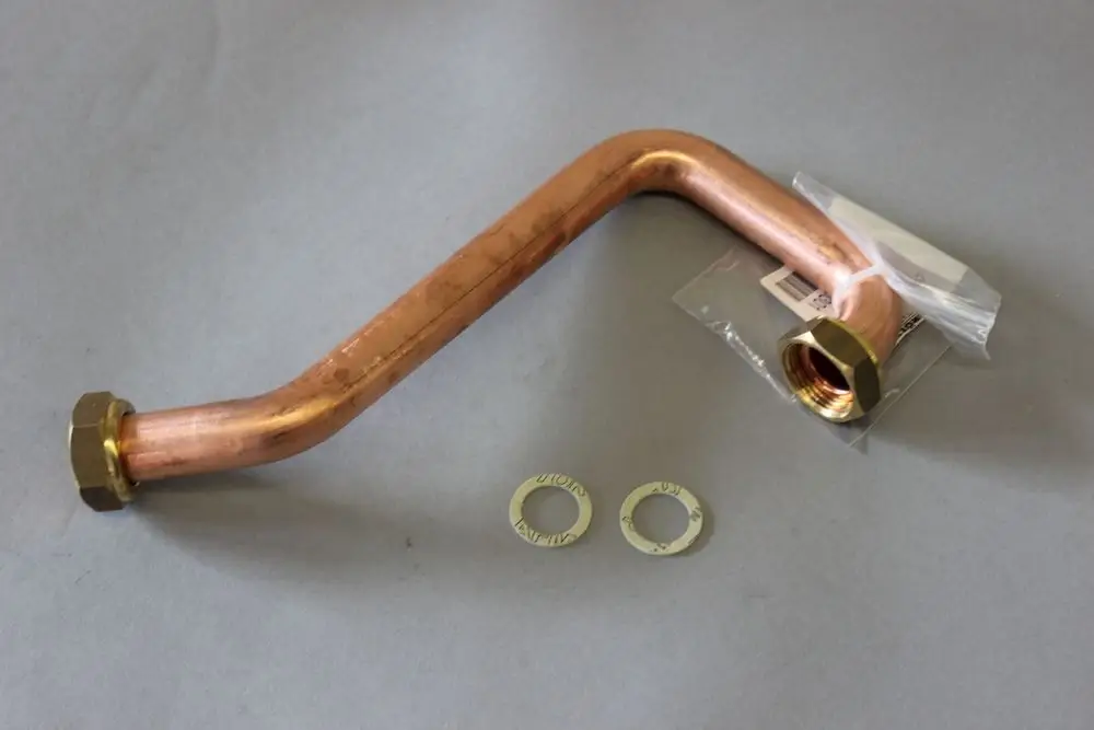 Kupferrohr mit einer gebogenen Form, einem Gewinde und zwei Unterlegscheiben. Teil eines Brötje-Gasbrennersystems, auf grauem Hintergrund dargestellt.