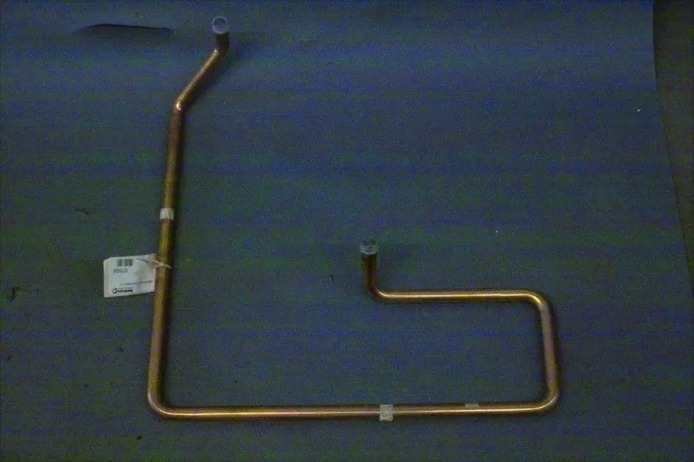 Kupferrohr mit zwei Anschlussstellen, gebogen, auf grauem Untergrund. Teil der Brötje Heizungsinstallation, für den Transport von Sauggas vorgesehen.