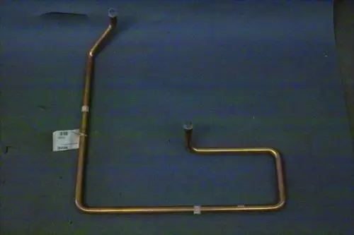 Kupferrohr mit zwei Anschlussstellen, gebogen, auf grauem Untergrund. Teil der Brötje Heizungsinstallation, für den Transport von Sauggas vorgesehen.