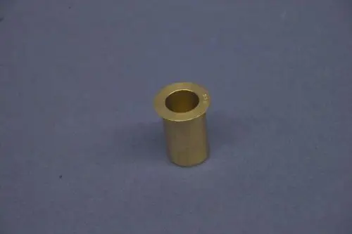 Brass nozzle from Brötje, cylindrical shape with an open end, sitting on a gray surface.
