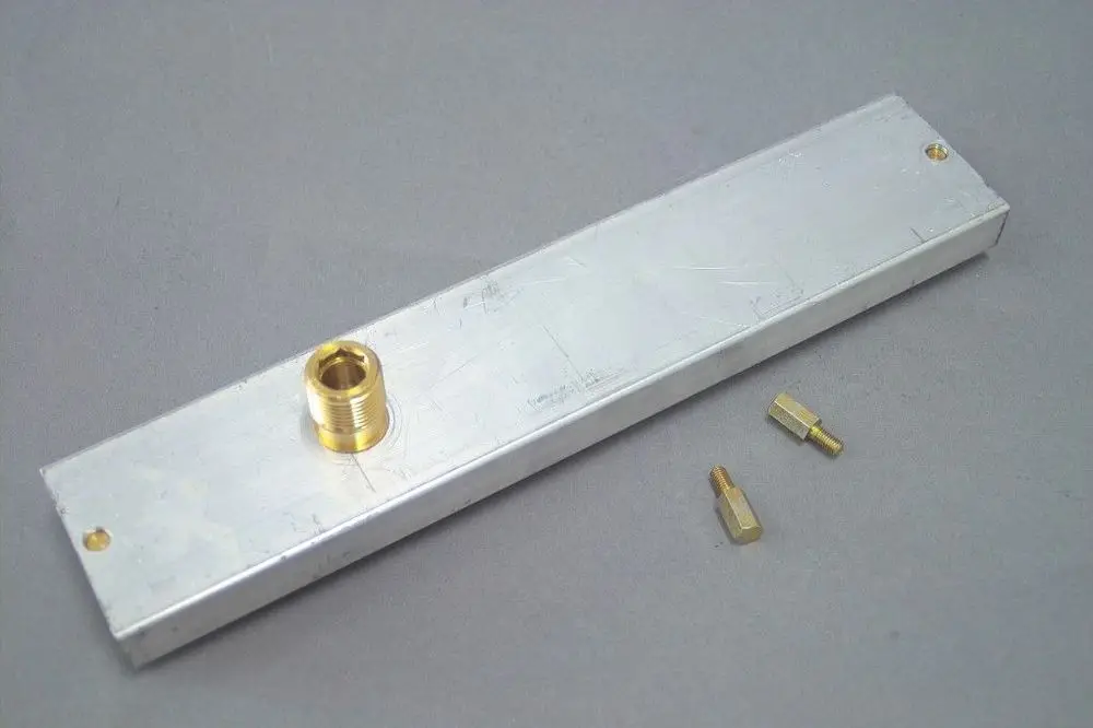 Düsenplatte aus Aluminium mit einem goldenen Anschluss und zwei kleinen Messingverbindern. Produkt von Brötje, geeignet für LL-Gas-Anwendungen.