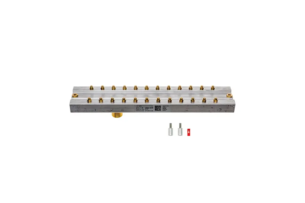 Umbausatz von Brötje mit einem Aluminium-Gehäuse und mehreren Anschlussbuchsen, sichtbar auf einer grauen Oberfläche. Zwei separate Adapterstücke liegen daneben.