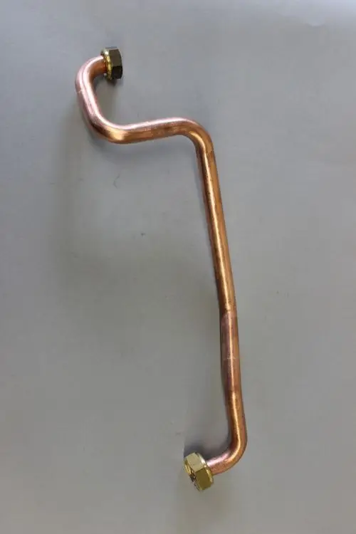 Kupferrohr mit zwei goldenen Gewindeverbindungen, hergestellt von Brötje. Das Rohr hat eine gebogene Form und dient vermutlich als Gasanschlussrohr.