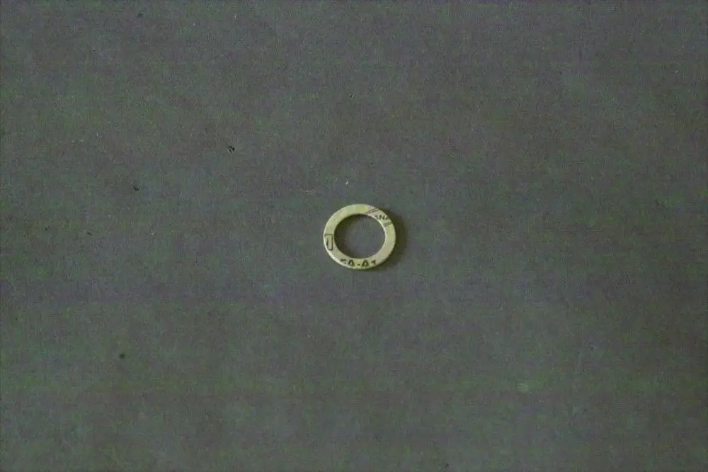Scheibe aus Metall mit einem inneren und äußeren Durchmesser, offensichtlich eine Dichtung, möglicherweise von Brötje, auf einem neutralen Hintergrund platziert.