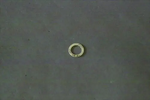 Scheibe aus Metall mit einem inneren und äußeren Durchmesser, offensichtlich eine Dichtung, möglicherweise von Brötje, auf einem neutralen Hintergrund platziert.