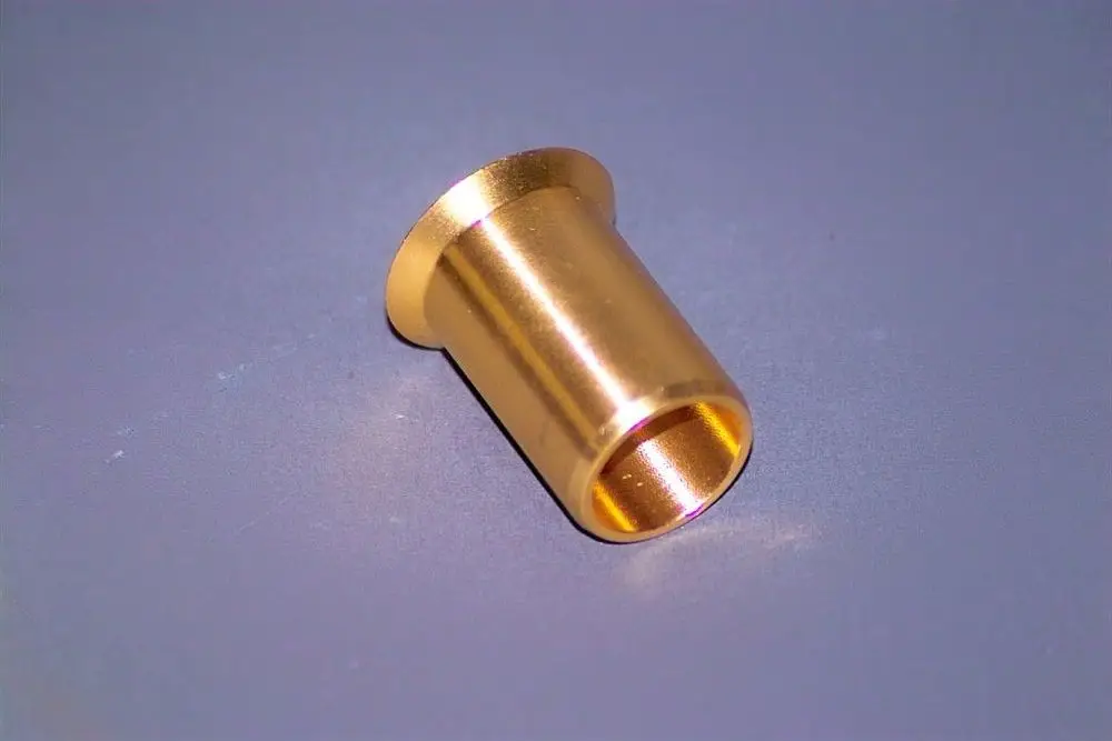 Goldfarbene Metallhülse auf grauem Hintergrund, möglicherweise Teil eines Heizsystems, hergestellt von Brötje.